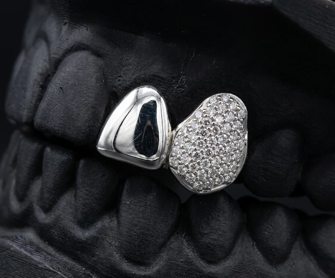 Iced canine paired with a solid lateral incisor in silver